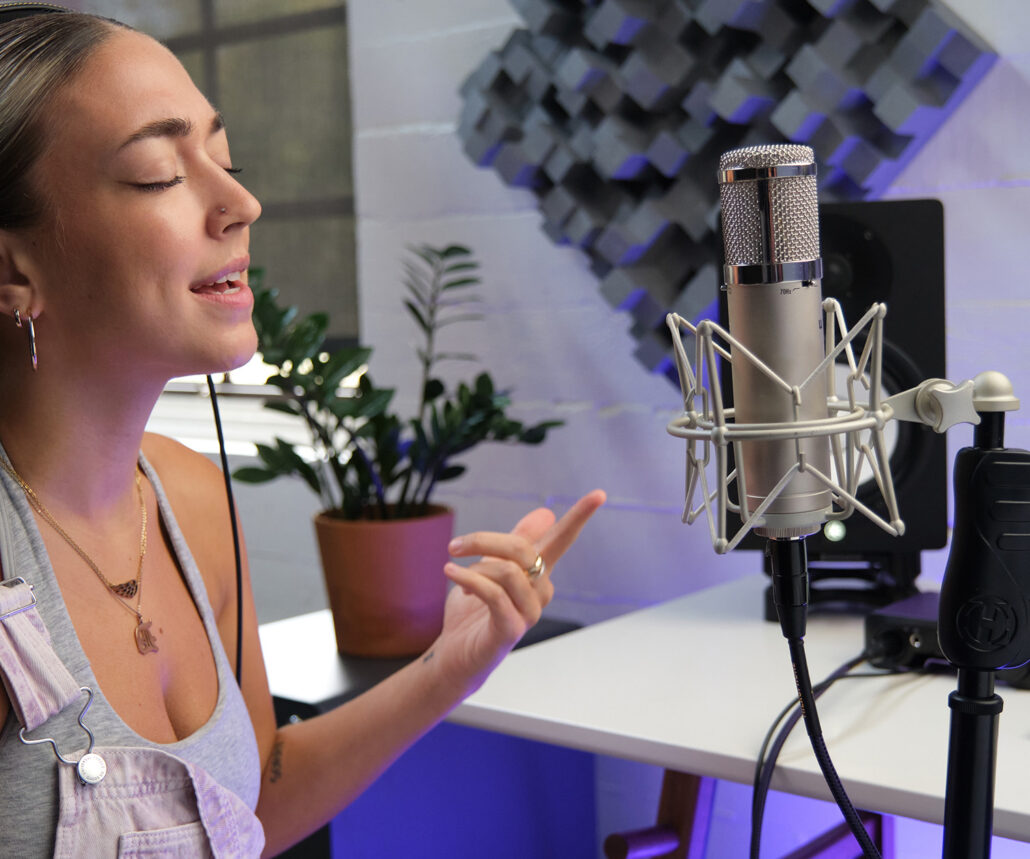 Woman singing into microphone and pointing at it